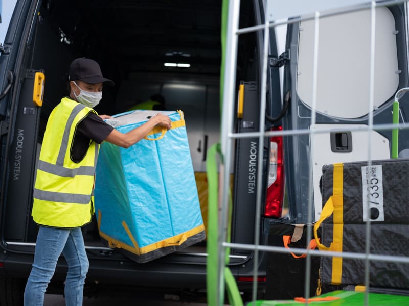 Zustellfahrer beim Entladen eines Transporters